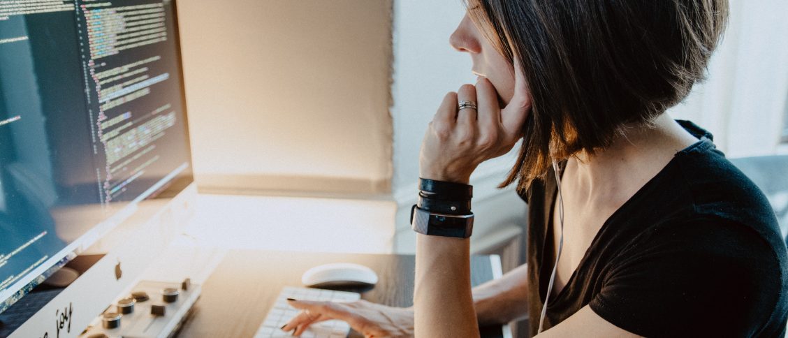 mulher olha para o computador com atenção