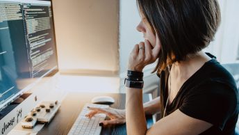 mulher olha para o computador com atenção